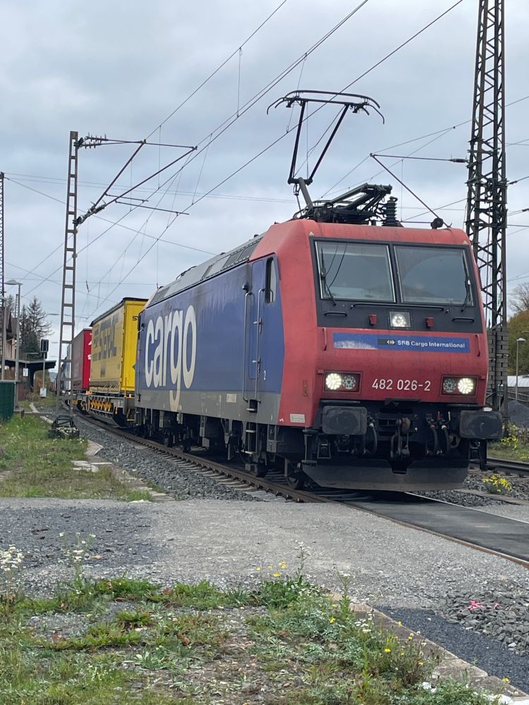 Locomotive 482-026 waiting patiently in Flieden for overtakes from high speed rail. It's an overcast day, the train is facing the south towards Hanau.