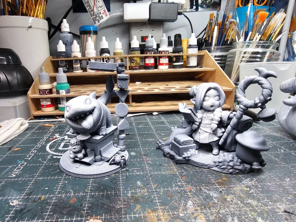 Photo of two figures unpainted.  Jeffy from Marvel Rivals on the left and Marcille from Delicious in Dungeon