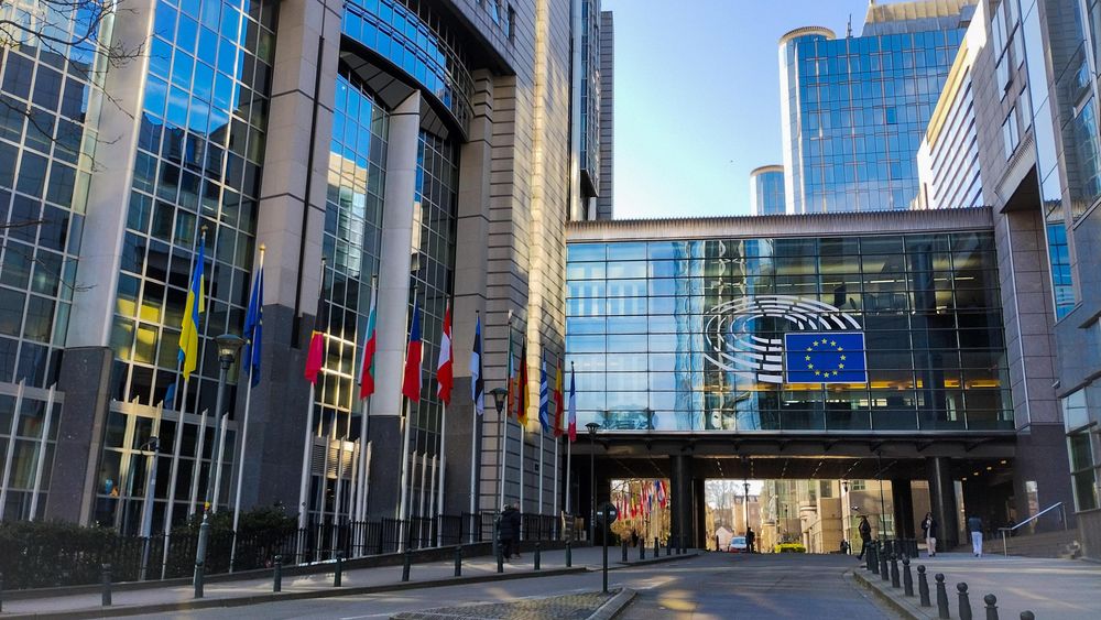 Detail of the European Parliament building in Brussels with flags and the logo of the Parliament