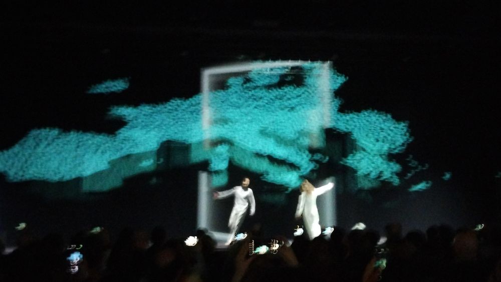 A picture of two dancers in white performing in front of a map of the EU