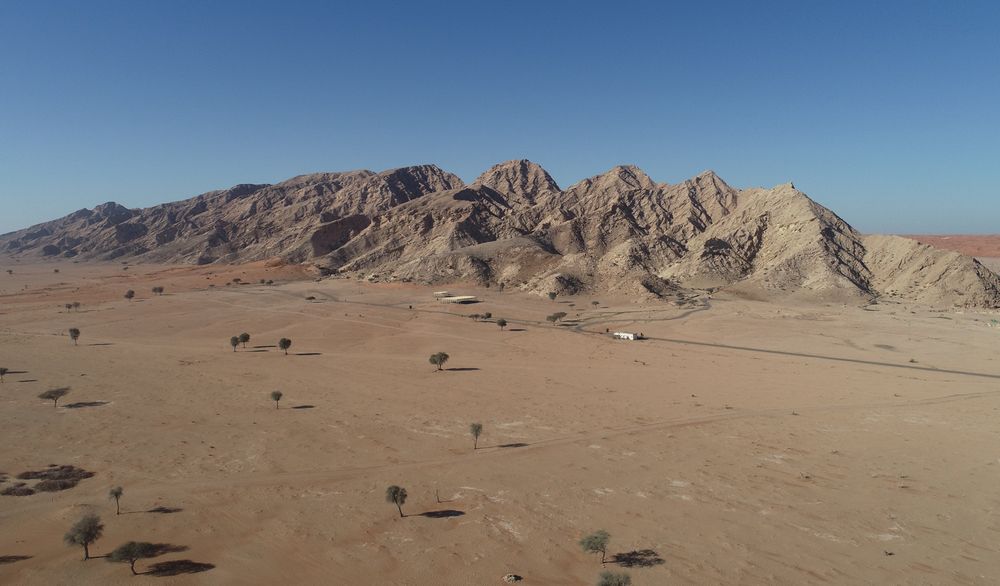 Overview of the 10 km long Jebel Faya mountain and the plain with the archaeological sites in front. The ridge forms a barrier to the Rub’ al Khali desert. (photo: Sharjah Archaeology Authority)