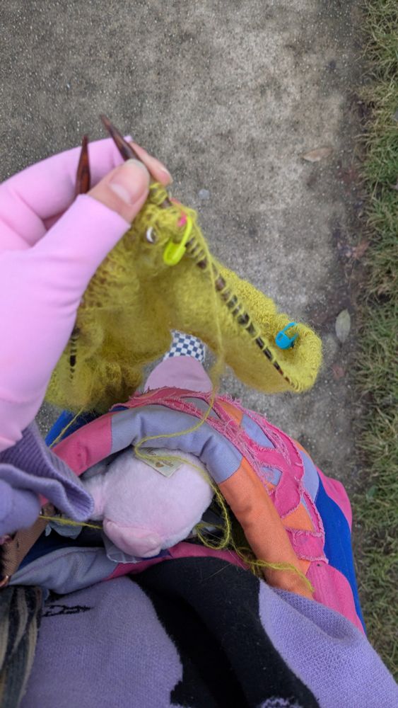 Me walking and knitting, wearing pink gloves