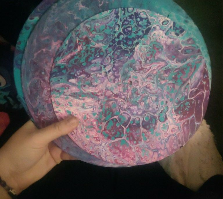 Paint pouring on vinyl records in various shades of blue, pink, and purple.