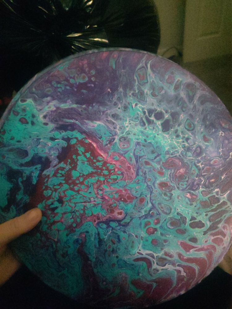 Paint pouring on vinyl records in various shades of blue, pink, and purple.