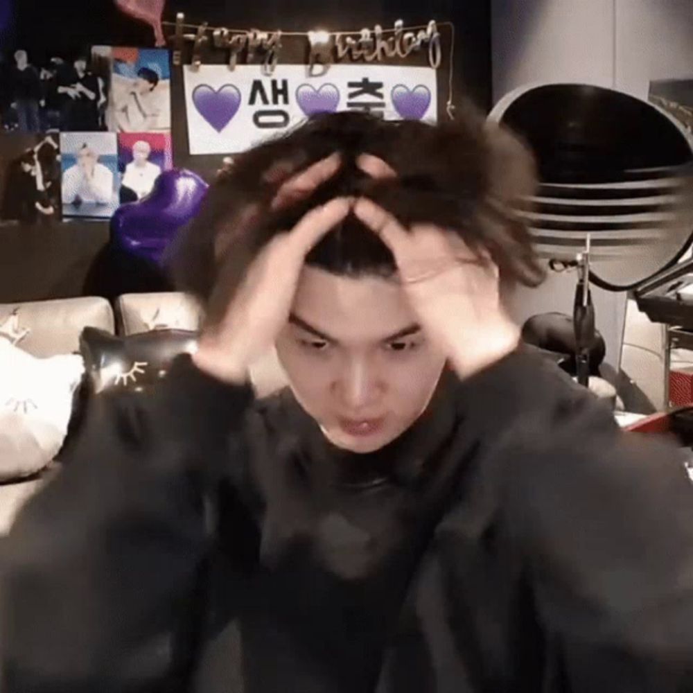 a young man is holding his head in front of a sign that says happy birthday