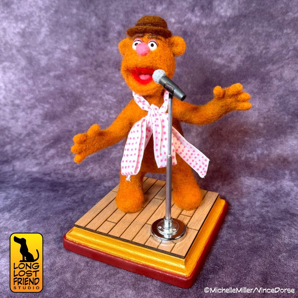 Needle felted Fozzie Bear character doing standup comedy
felted figure by @runredrun.bsky.social
base and microphone created by @vincedorse.bsky.social