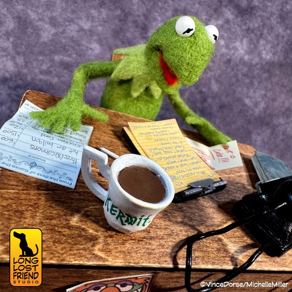 Close up of the needle felted Kermit the Frog sitting at his desk looking over his paperwork for the show. Mixed media diorama made by Vince Dorse and Michelle Miller of Long Lost Friend Studio