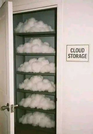 A humorous image showing a closet with shelves filled with fluffy white cotton resembling clouds. A sign on the wall next to the open door reads “CLOUD STORAGE,” playing on the double meaning of digital cloud storage and literal clouds stored on shelves.