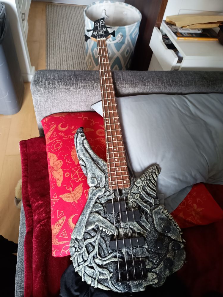 heavily modified bass guitar with all bones carved into it