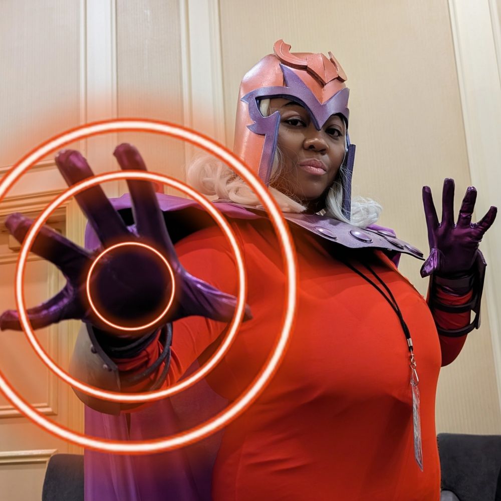 Patchouliies cosplaying Magneto, standing at a side view angle with their hands splayed out. On their right hand are three red glowing circles emitting from it to simulate the magnetic power shown in X-Men: The Animated Series