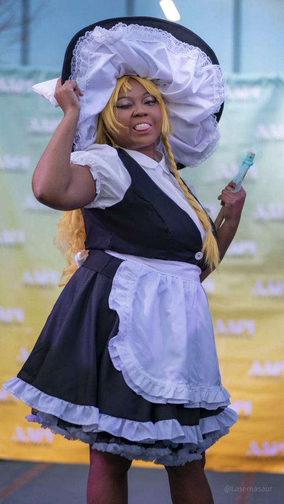 patchouliies dressed as Marisa Kirisame posing while holding the edge of their hat and winking