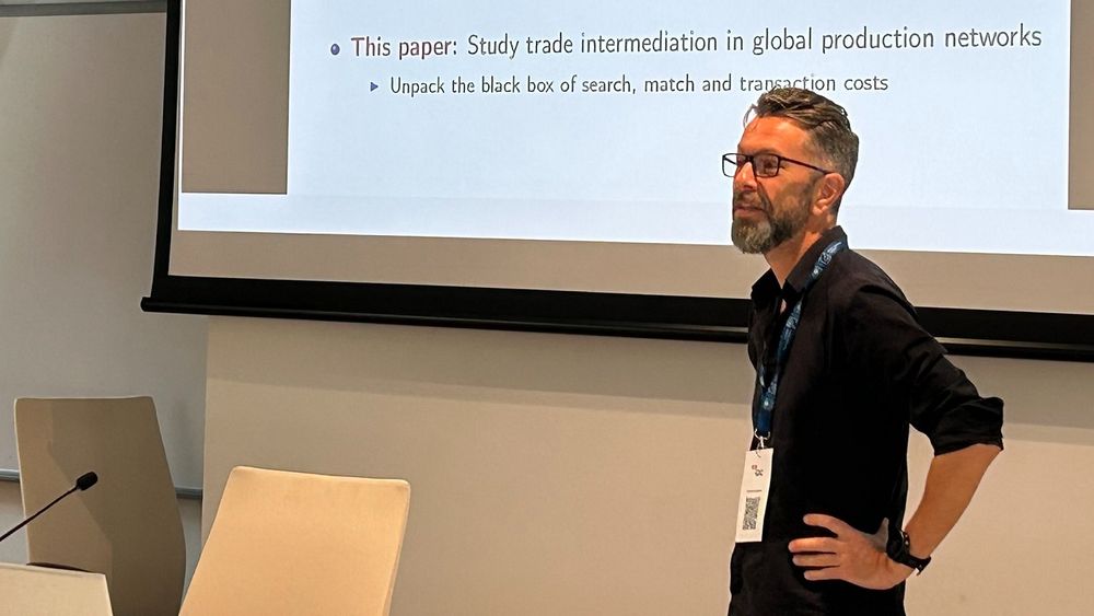 Keynote speaker Andreas Moxnes from the Norwegian Business School stands in front of his presentation while delivering his speech.