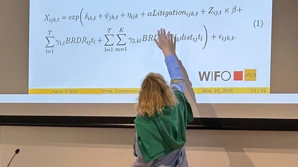 Agnes Kügler, a RETHINK-GSC researcher and a senior economist at the WIFO, points to the formula used in her latest research on the effects of patent litigation and trade, which is displayed on the screen.