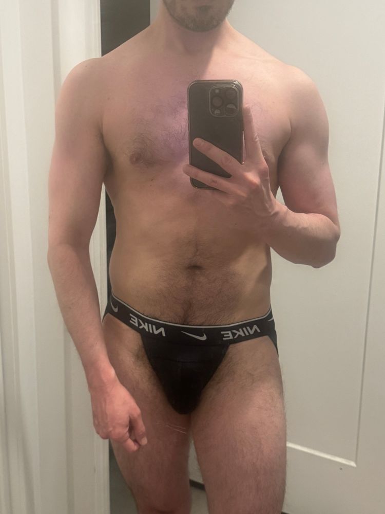 mirror selfie, adifferentjon in his favorite black Nike jockstrap, trying out a muscle pose after the gym on a sunday 