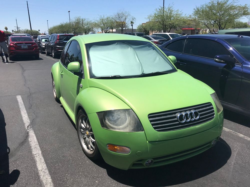 A lime green “BeeTTle” in a parking lot. 