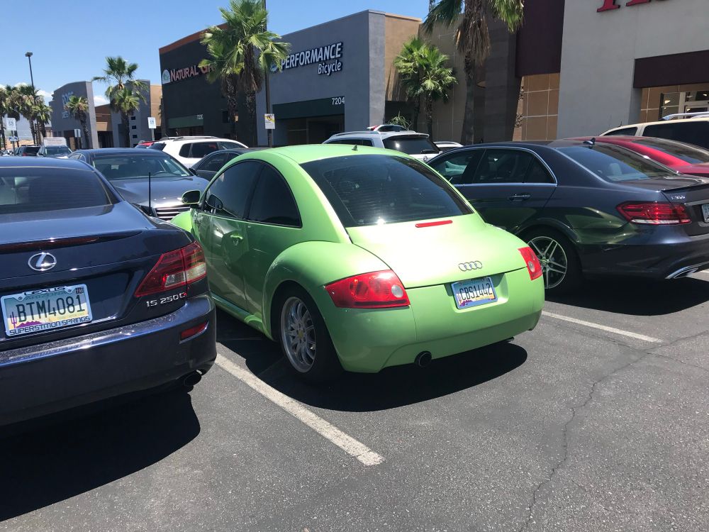 A lime green “BeeTTle” in a parking lot. 