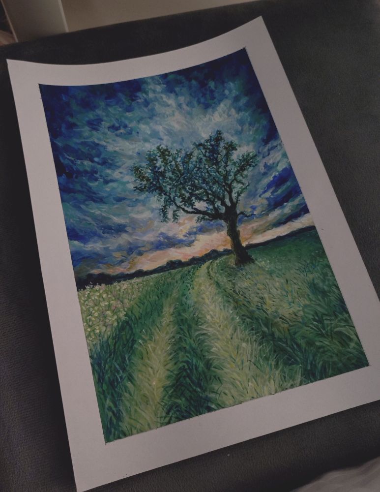 A photo of the same painting, the paper sitting on a grey surface, showing the white border around the painting due to using masking tape.