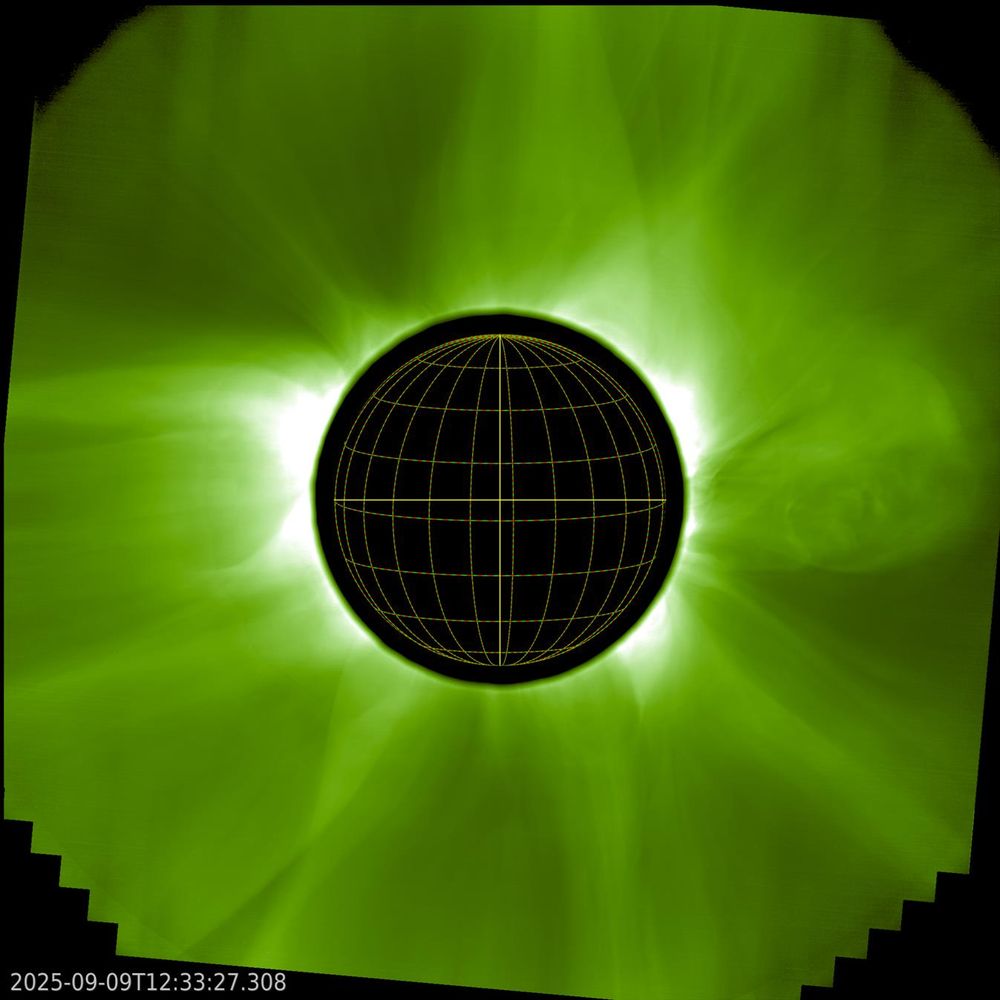 Black disk surrounded by a greenish solar corona