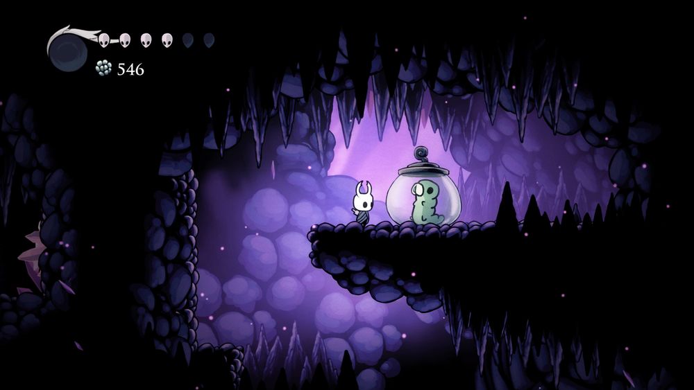 A hollow knight screenshot featuring one of the cute grubs! They're in a jar being held captive, oh no!