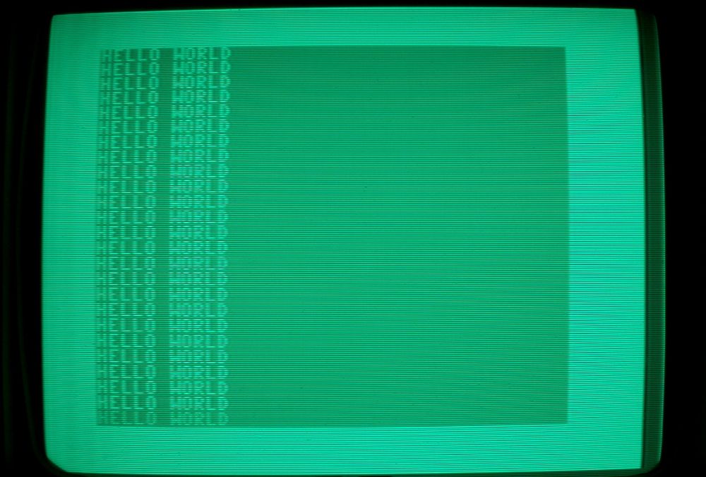 The words "HELLO WORLD" repeating on a green CRT screen.