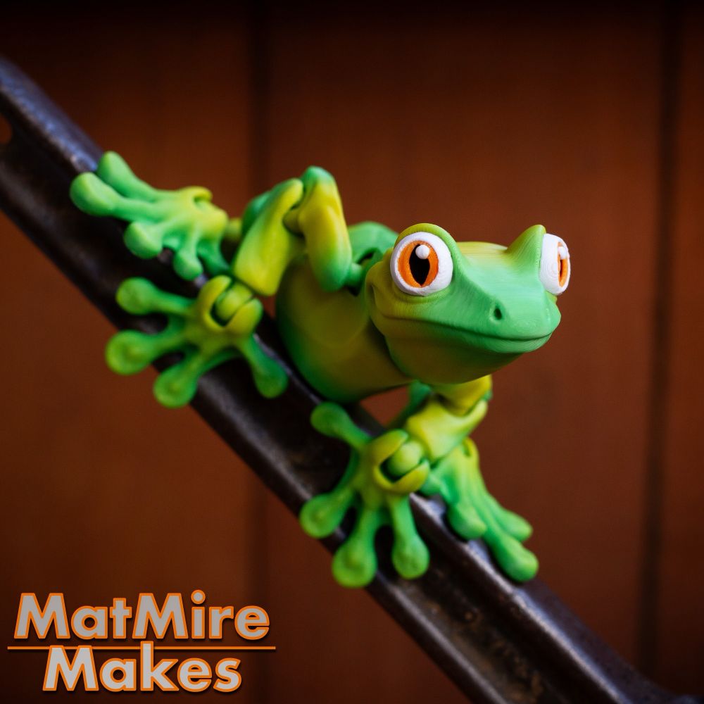 Green 3D printed frog. Magnetically holding on to a metal handle.
