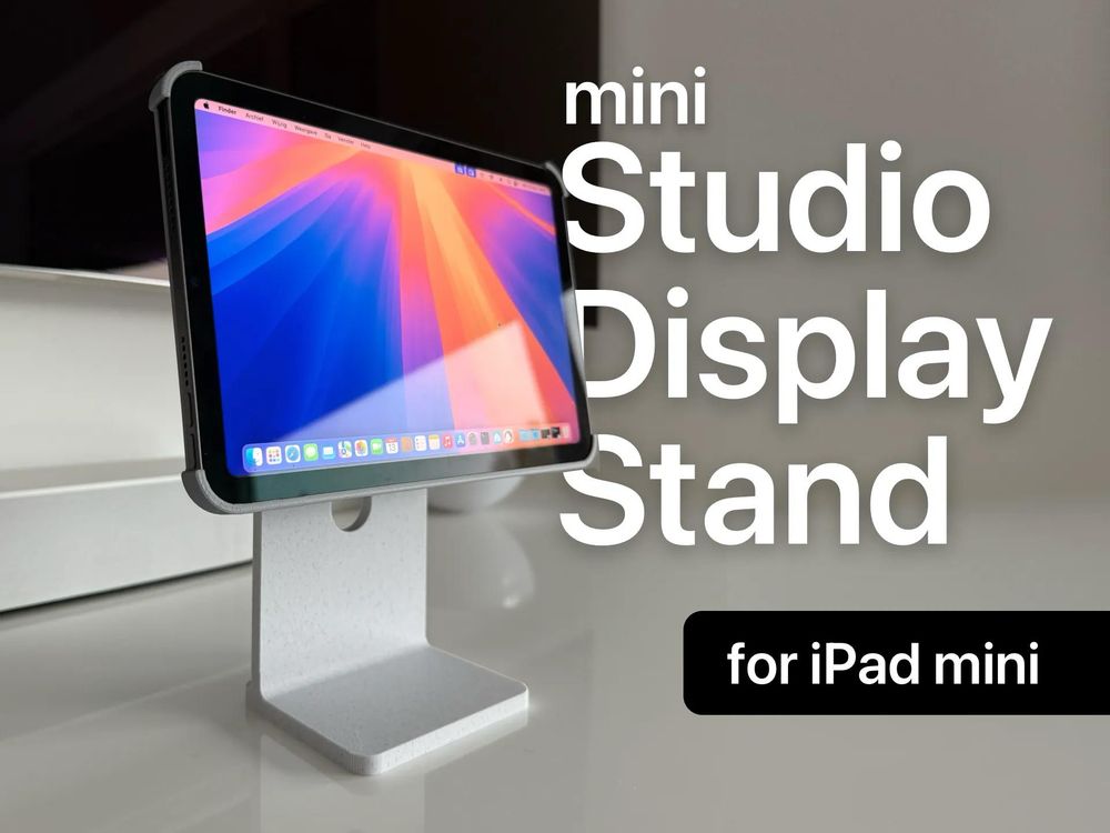 A sleek, modern display stand holds an iPad mini in landscape orientation, mimicking the look of a desktop studio display. The stand features a minimalist design with a white, textured finish and a circular cutout in the support column. Text overlays on the image read “mini Studio Display Stand for iPad mini,” emphasizing the product’s purpose. The iPad screen displays vibrant colors in a macOS-style interface.