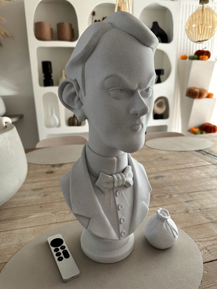 3D printed bust of Wellington, one of the Twins from Disney World’s Haunted Mansion. Printed in marble colored PLA filament. Pictured next to an Apple TV Remote to show the scale.