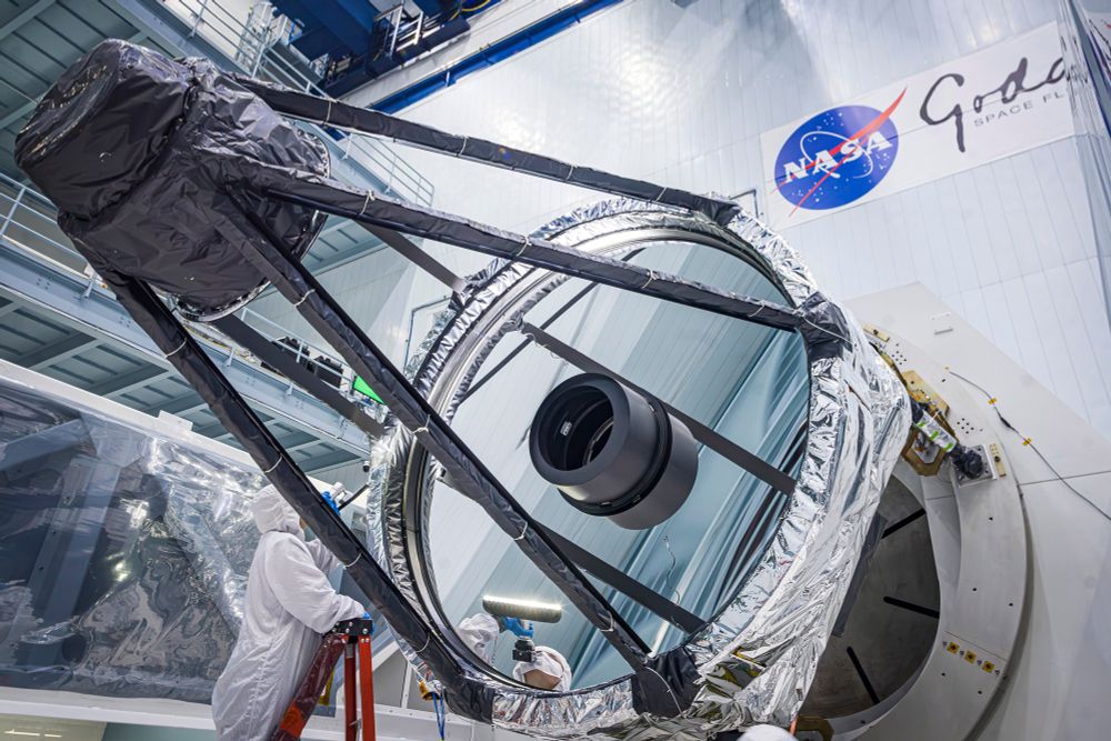 Optical Engineer Bente Eegholm inspecting the Primary mirror of the Roman telescope after it was removed from the shipping container. Credit: NASA, Chris Gunn