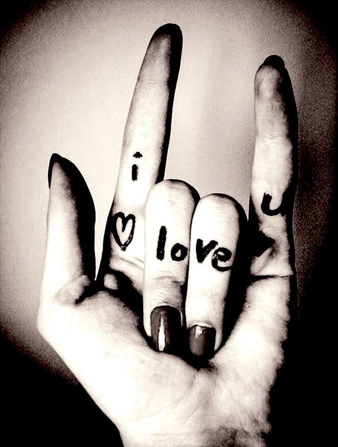 The sign language hand gesture for, ‘I love you’; & it also written on the fingers