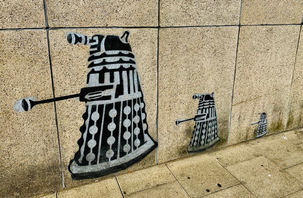 Three Daleks stencilled on a wall