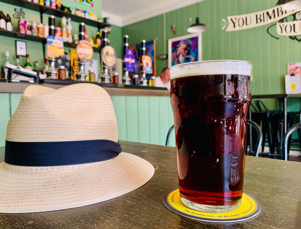 Pint of Brown Ale with straw hat.