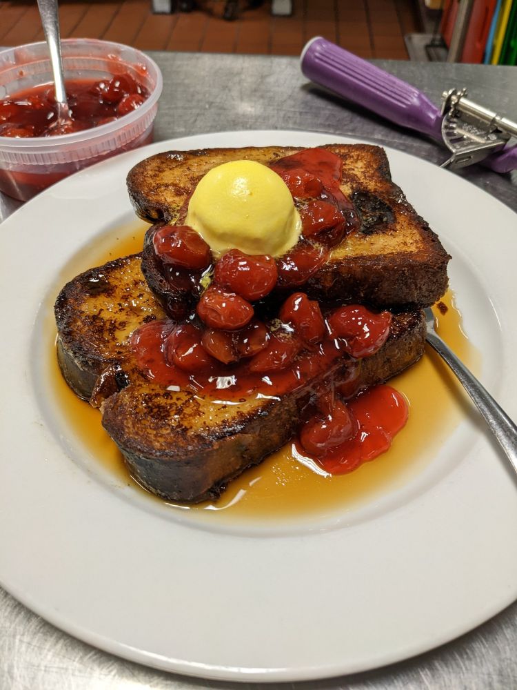 Dried cherry and raisin challah french toast topped with cherry compote and cultured butter