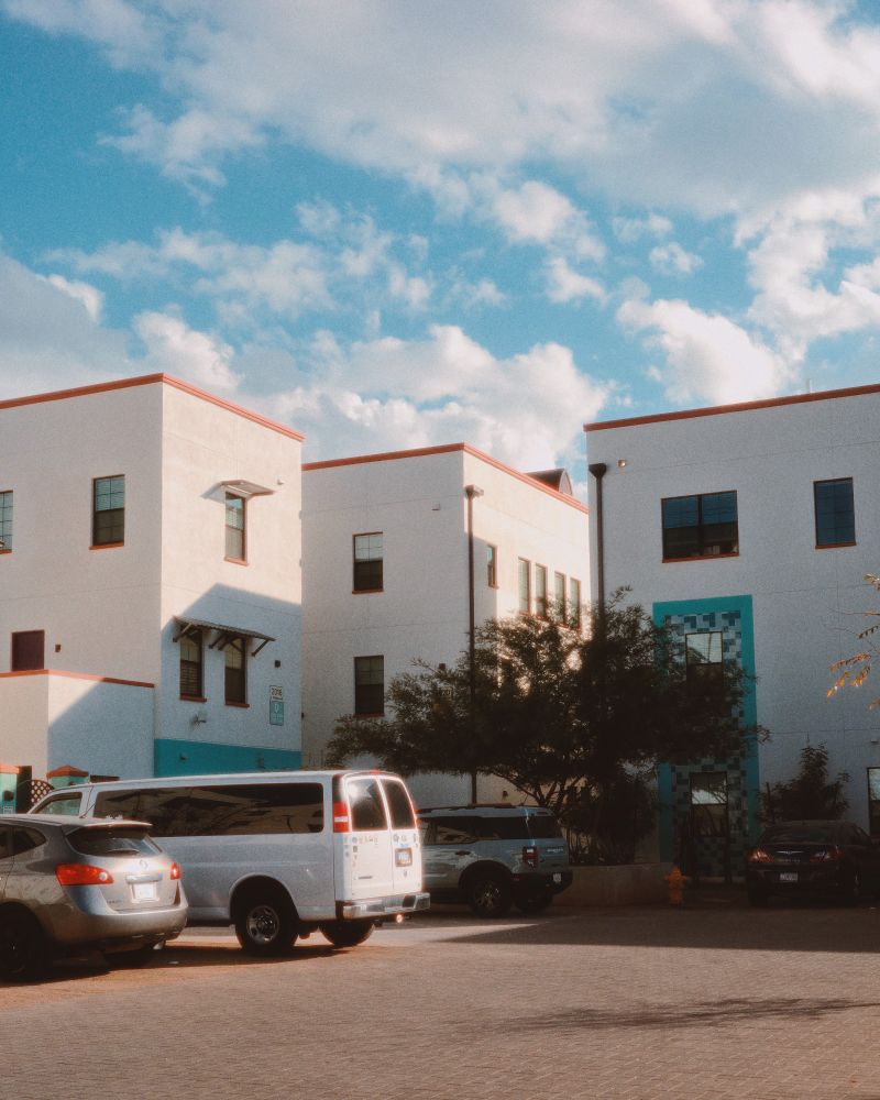 photo of buildings by a parking lot