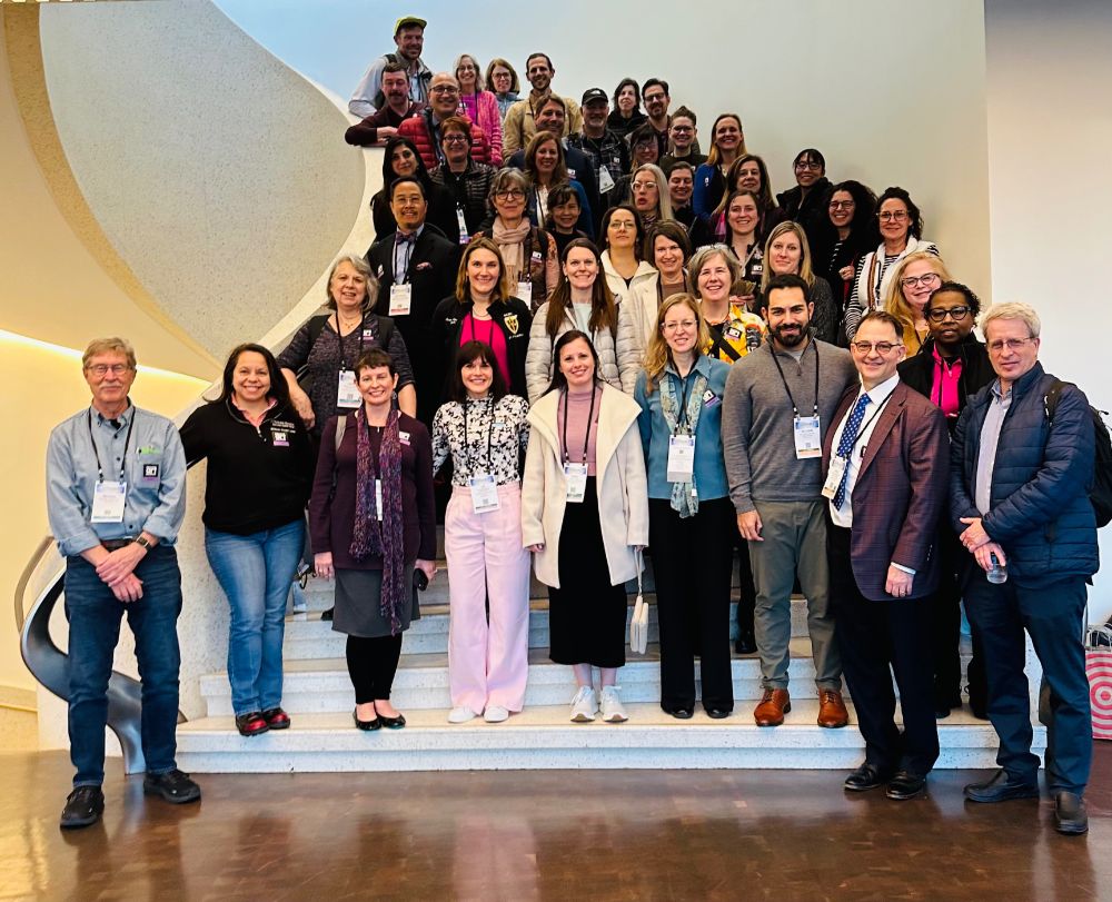 A group of about 50 hospice & palliative medicine clinicians standing on a stairway.