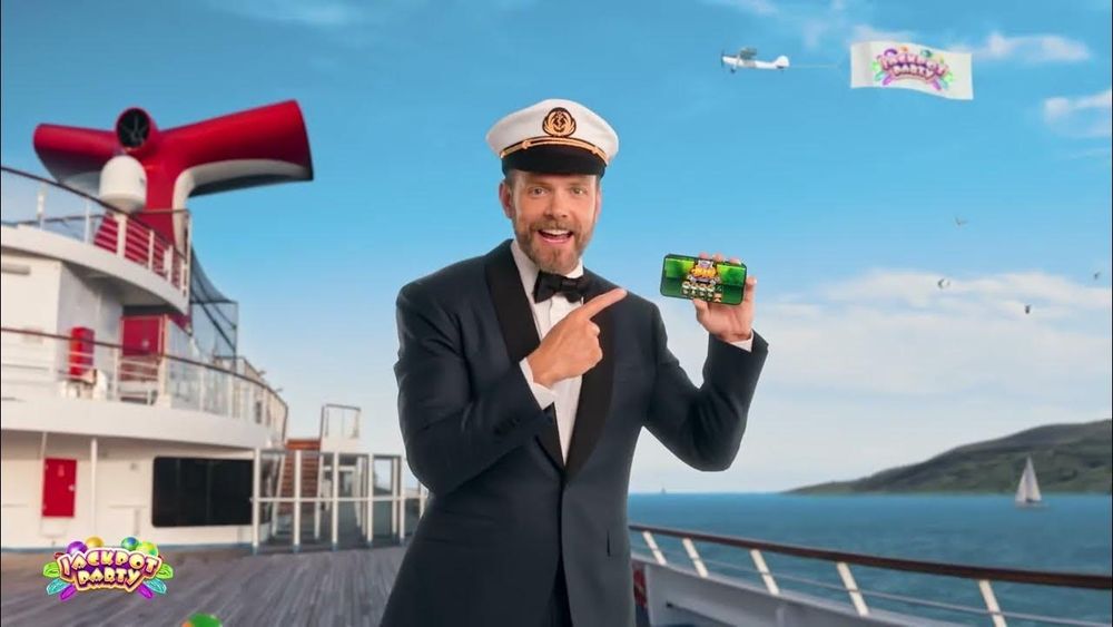 Joel McHale dressed like the captain of a boat going to Little Saint James Island hawking the "Jackpot Party Casino" app
