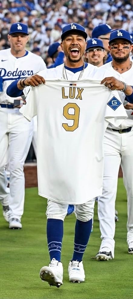 mookie walks towards gav(offscreen) holding his ws jersey. he looks extremely joyous 
