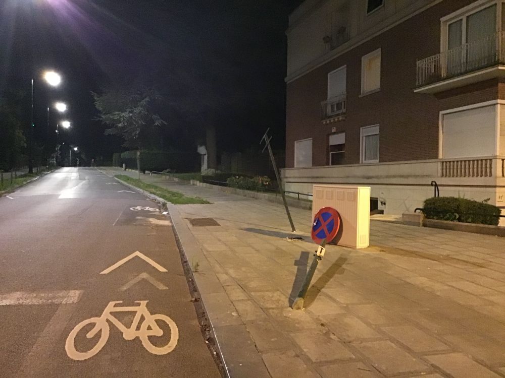 Croisement av. Franklin Roosevelt / Av. de l'Orée.
Panneau d'interdiction de stationner et panneau indiquant le nom de la rue qui sont défoncé par terre, emboutis par un véhicule motorisé.