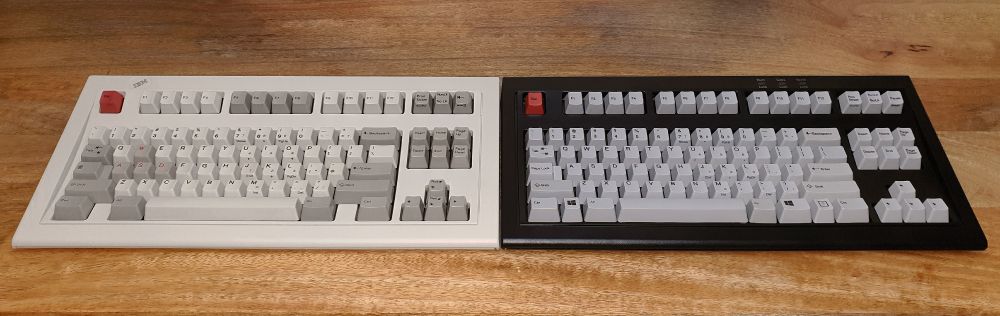 A photo of an IBM Model M Space Saving Keyboard and a Unicomp Mini Model M side by side.