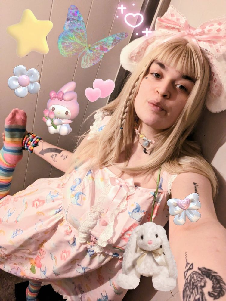 edit of Lush in a pink carebears dress, striped rainbow socks, and white bunny / puppy ears with a pink bow