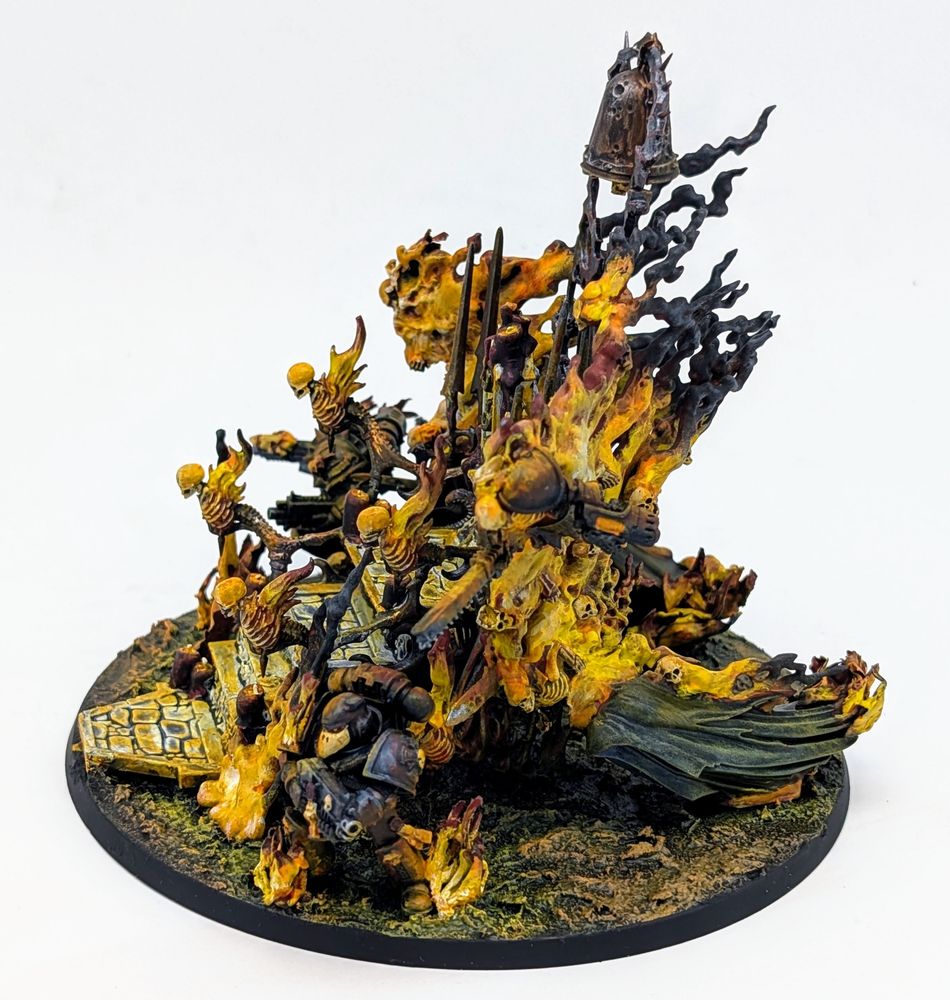 A sepulchre wreathed in flames. A large bronze bell hangs overhead. Skeletal warriors and space Marines emerge from the flames