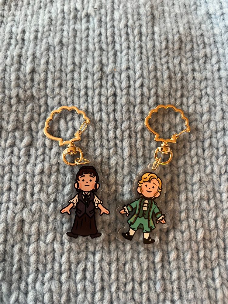 two little keychain charms side by side- one is mary our flag means death and the other is stede our flag means death
