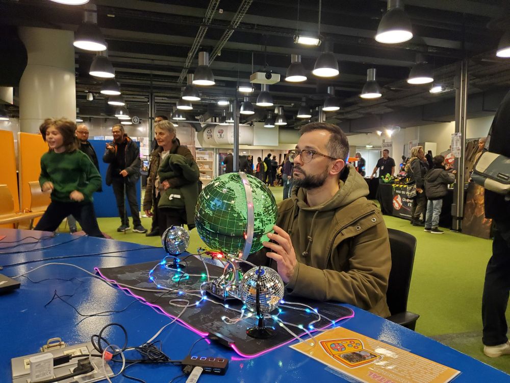 A great guy sitting in front of the globe and looking at the screen. He's slowly rotating the LED globe to play the game. On the back we can see a child jumping on a yoga ball, another controller made by incontrolab.