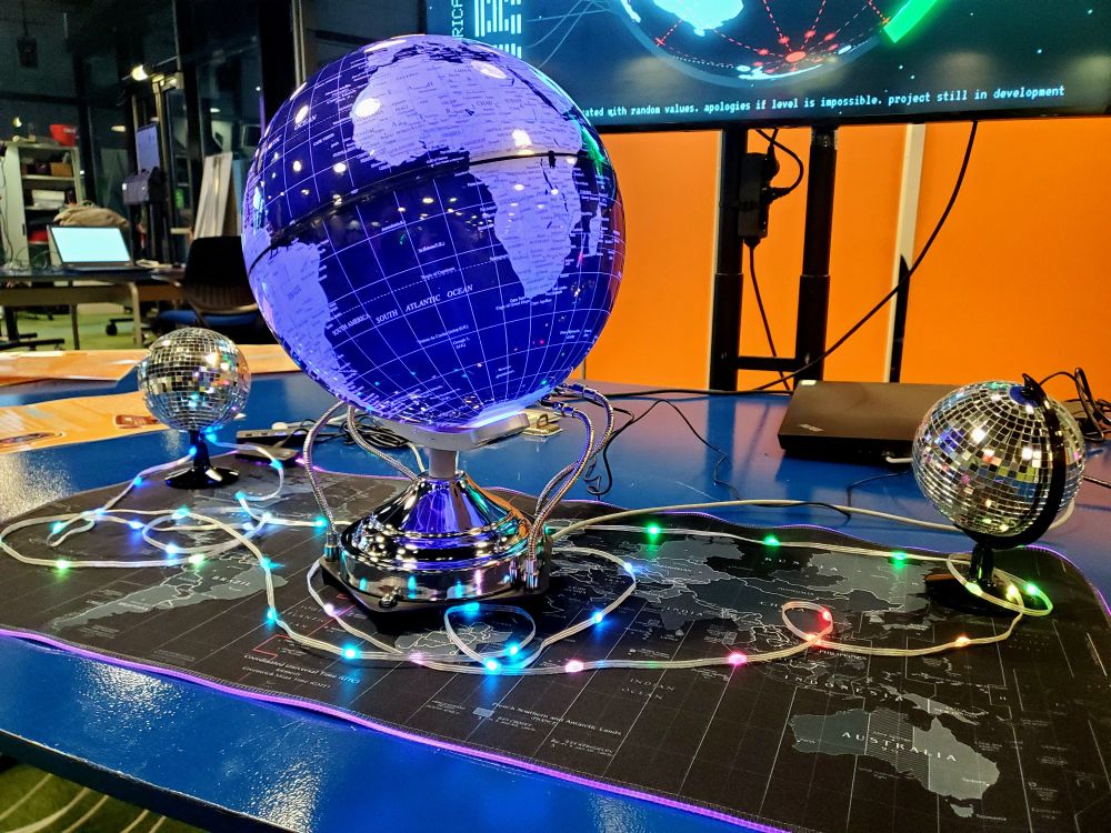 The alternative controller used to play Orbital : a globe modified to display RGB lights and mimick the controls of a computer mouse.
It is disposed on a RGB mouse pad of which the illustration is a black and white map of the world.
There is two little disco globes and an LED strip disposed on it.