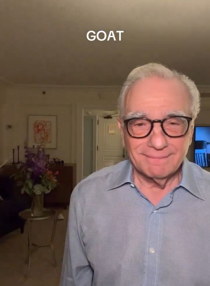 Martin Scorsese wearing thick black glasses smiling under the acronym GOAT as posted by his daughter Francesca