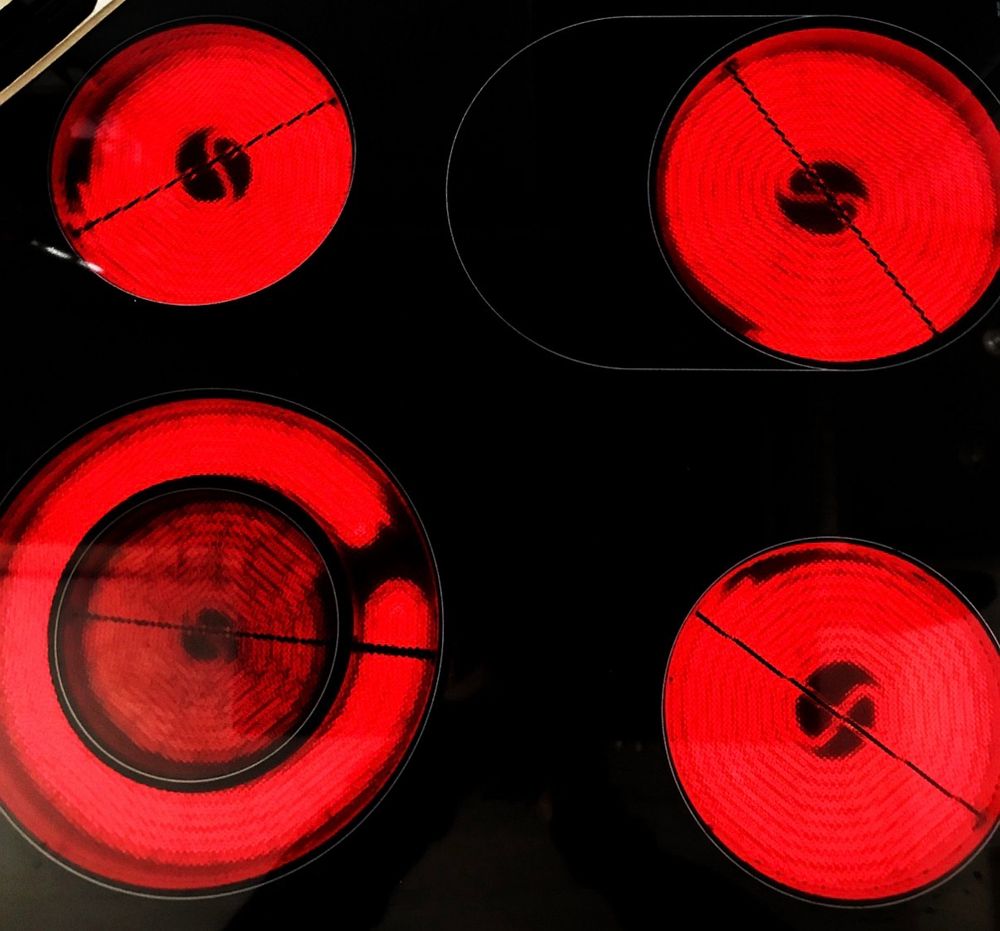 Cream Kochfeld mit 4 aktiven Kochplatten, die alle rot leuchten. 