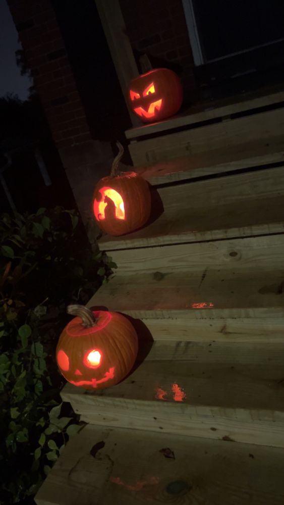 Three glowing jack-o’-lanterns on ascending stairs 