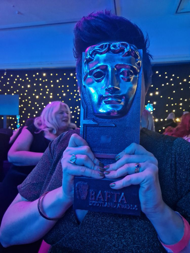 Stef is holding the BAFTA to her face