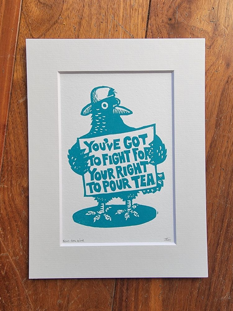 A lino print of a bird holding a sign stating you've got to fight for your right to pour tea 