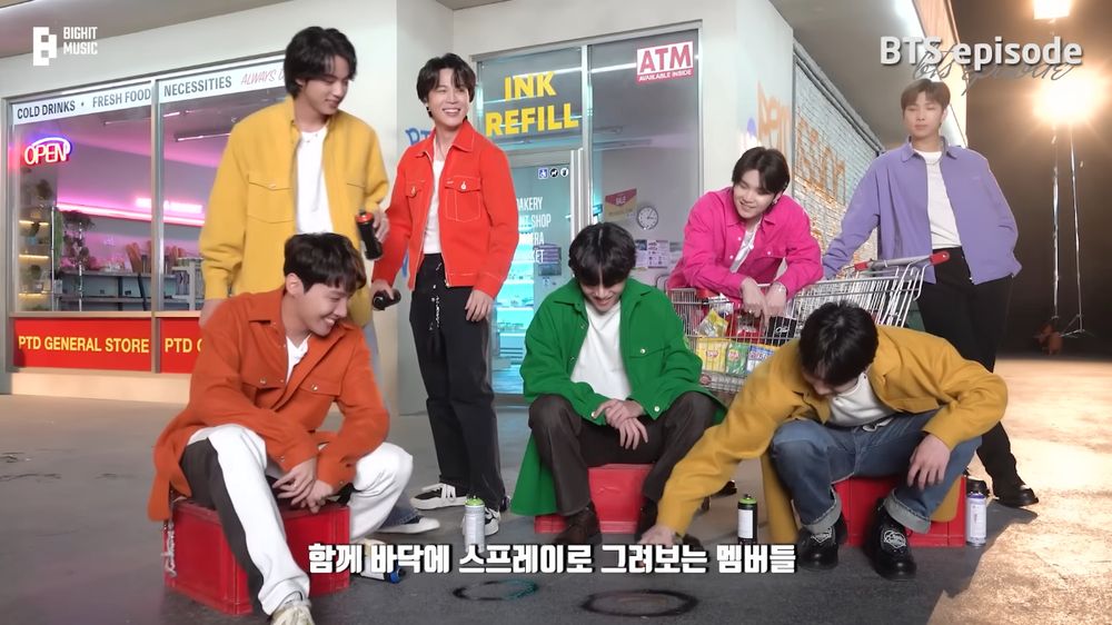 Bangtan gathered in front of a convenience store set, dressed in bright colors