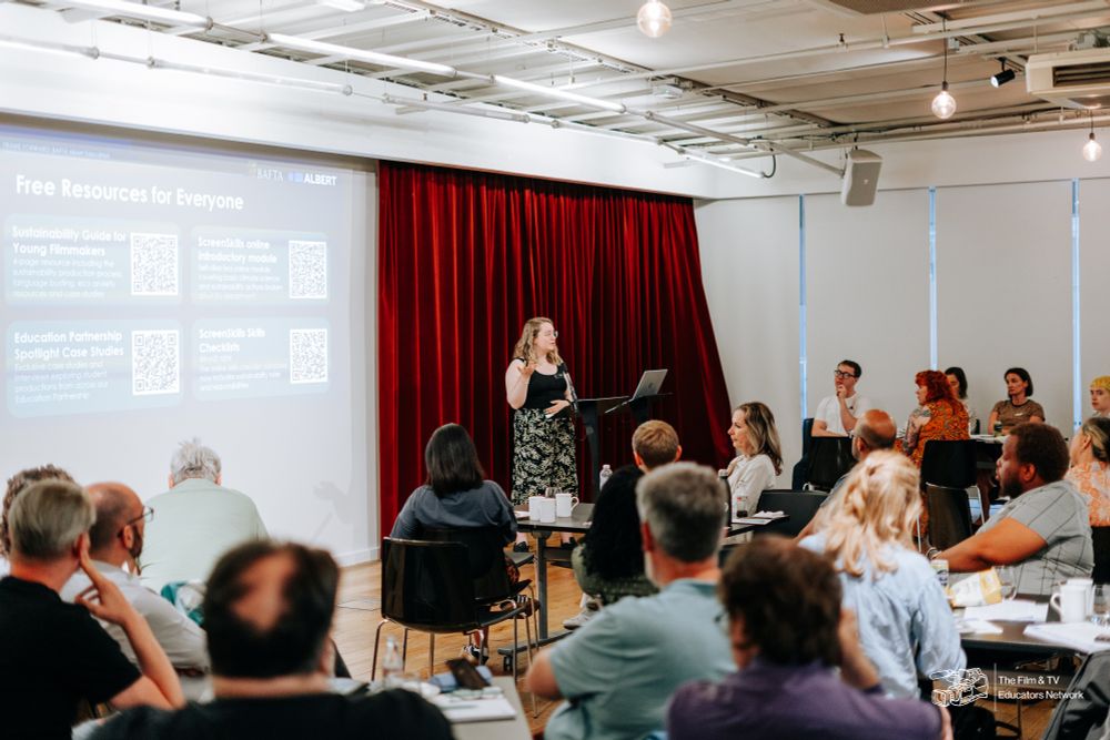a blonde woman presenting in front of a screen